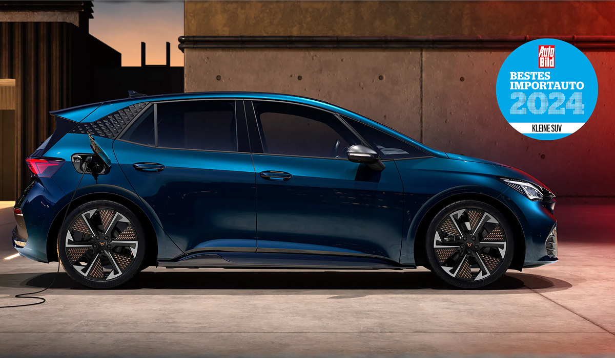 CUPRA Born beim Laden mit Auto Trophy Plakat vor urbanem Hintergrund in Seitenansicht